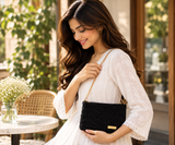 Black Shoulder Purse carried by model in cream outfit at cafe
