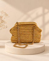 Golden crochet clutch on a cream pedestal, HouseOfReena