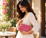 Pink Festive Clutch carried by model in sunlit cafe